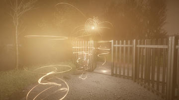 A shot from the game outside some gates with a shimmering orb of energy floating in the air.
